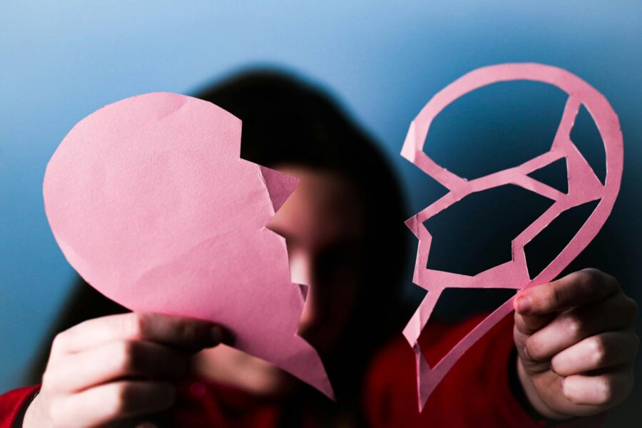 Mujer sosteniendo un corazón roto